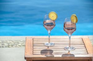 米科利维亚Natura Villas in Naxos的托盘上放上两杯酒和一片石灰