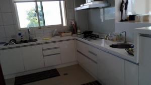 Gongzhao叭哩沙喃民宿 的厨房配有白色橱柜、水槽和窗户。