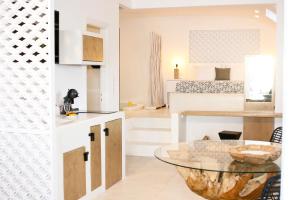 阿斯提帕莱亚镇Anatoli Luxury Studios & Suites的厨房以及带玻璃桌的起居室。