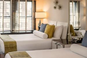 纽约70 Park Avenue Hotel的客厅配有白色沙发和窗户