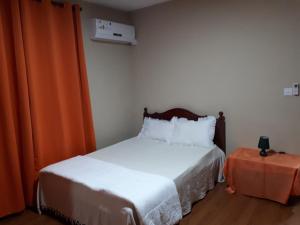 沙马雷勒Chamarel Mirador Studio的一间卧室配有床和橙色窗帘