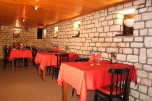 La Ferté-MacéTaverne de la paix的餐厅设有红色的桌椅和砖墙