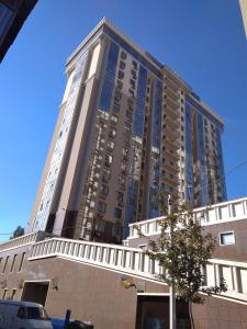 敖德萨Асташкина的一座高大的公寓楼,前面有一棵树