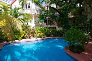 圣佩德罗棕榈树海滨套房酒店的大楼前的大型蓝色游泳池