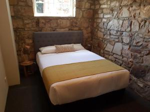 里士满里士满爱慕斯酒店的石墙房间内的一张床位