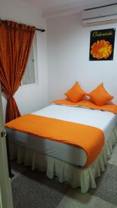 比亚维森西奥Casa Villavicencio的一间卧室配有带橙色枕头的床和窗户。