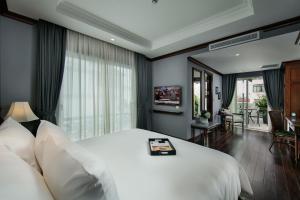 河内La Sinfonía Majesty Hotel and Spa的卧室设有一张白色大床和一扇窗户。