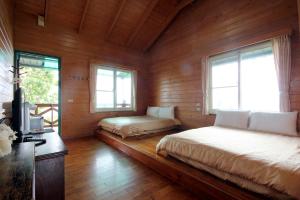 仁爱乡清境小太阳景观木屋 的木制客房内的一间卧室配有两张床
