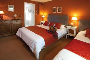 奥贝奈古韦内尔酒店的卧室设有两张床铺和橙色墙壁