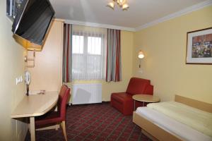 瓦兹加斯赫夫卡木尔酒店的酒店客房配有一张床、一张桌子和一把椅子。