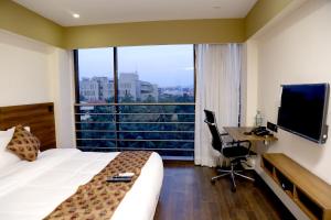 孟买Hotel Mumbai House Andheri East, Mumbai的酒店客房配有一张床和一张带电脑的书桌