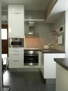 卡尼洛瑞维拉Casa Lucia的厨房配有不锈钢用具和白色橱柜