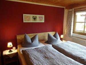 奥伯斯特多夫Landhaus Schmid的卧室设有红色的墙壁和一张带枕头的床