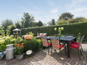 奥斯楚特B&B Het Pronkbed的花园内带桌椅的庭院