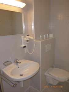 斯皮特安德劳Kolpinghaus Spittal的白色的浴室设有水槽和卫生间。