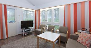 卡拉约基Holiday Club Kalajoki Cottages的客厅配有电视、椅子和窗户。