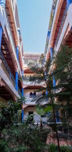 马拉喀什中央宫殿酒店的一座大建筑前面有楼梯和树木