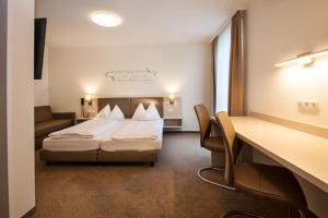 林茨洛可莫蒂夫酒店的配有一张床和一张书桌的酒店客房