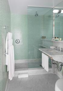 纽约海上酒店的一间带玻璃淋浴和水槽的浴室