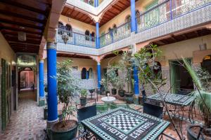马拉喀什中央宫殿酒店的室内庭院,配有桌子和盆栽植物