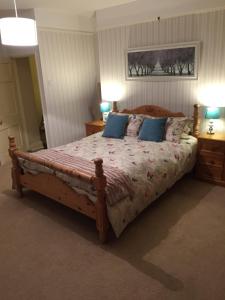 吉林汉姆Church Farm的一间卧室配有一张带蓝色枕头的大型木制床。