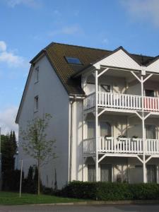巴贝Familie-und-Meer-2-Badezimmer-3-Schlafzimmer-Strandnah-im-Ostseebad-Baabe-Baabe的白色的大房子,设有白色阳台