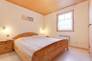 乌塞林Haus-am-See的一间卧室设有一张木床和一个窗户。