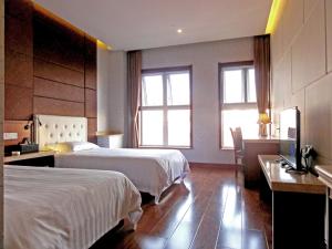 青岛青岛华奇凯帝酒店 的酒店客房配有两张床和一张书桌