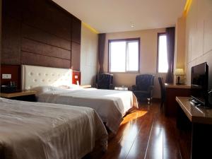 青岛青岛华奇凯帝酒店 的酒店客房设有两张床和一台平面电视。