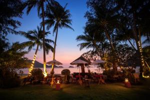 象岛一米阳光精品海滩Spa度假村的海滩上的餐厅,晚上种有棕榈树