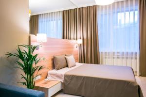 阿斯塔纳阿斯塔纳伊寇公寓酒店的酒店客房,配有床和植物