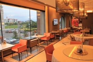 乌兰浩特锦江之星乌兰浩特兴安盟政府店的餐厅设有桌椅和大窗户。