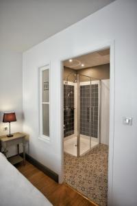 内拉克亨利四世酒店的一间卧室设有通往淋浴的玻璃门
