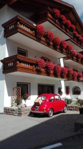 奥蒂塞伊沃尔特加尼酒店的停在大楼前的红色汽车