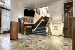 格丁尼亚水手之家酒店的大堂设有楼梯和平面电视。