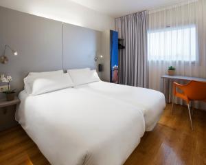 菲格拉斯B&B HOTEL Figueres的一张大白色的床,位于酒店客房内