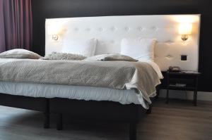 莫伦霍克莫伦-奈梅亨凡德瓦克酒店的一间卧室配有一张大床和大床头板