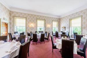 唐克斯特欧斯敦霍尔酒店的用餐室设有桌椅和窗户。