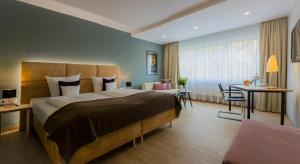 霍夫中心酒店的酒店客房设有一张大床和一张桌子。