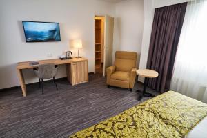 希佛萨姆兰佩夏克阿伦那帕阿姆拉酒店的酒店客房配有书桌、床和椅子。