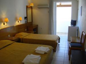 拉加纳斯安德里奥拉海滩酒店的酒店客房设有两张床和电视。