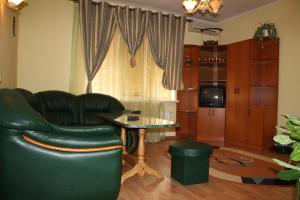 鲍里斯皮尔Комплекс отдыха "Престиж"的客厅配有黑色真皮沙发和桌子