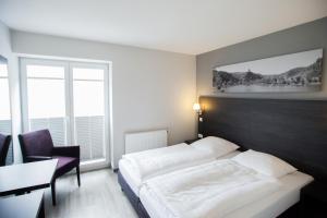 科赫姆科赫伊姆公寓式酒店的酒店客房设有一张床、一张书桌和窗户。