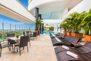比亚维森西奥GHL Hotel Grand Villavicencio的酒店庭院设有桌椅和游泳池。