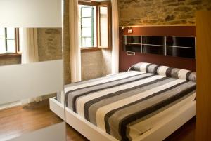 圣地亚哥－德孔波斯特拉多莫斯斯特拉公寓式酒店的一间卧室配有带条纹毯子的床