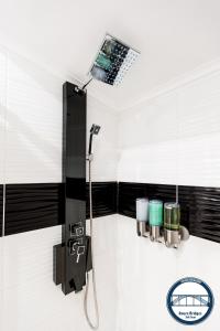 加亚新城杜罗河滨公寓的浴室铺有黑白瓷砖,设有淋浴。