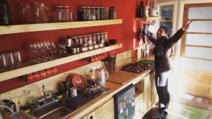 纳塔列斯港Treehouse Patagonia的站在厨房里拿着摄像头的女人