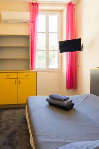 马赛租赁服务公寓的一间卧室配有床和一个带粉红色窗帘的窗户。