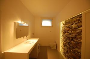 吉法Rustico Moderno的一间带水槽和石墙的浴室