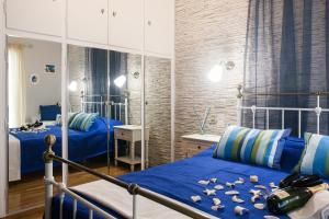雅典Elegant and Safe Gold and Blue Apartment walk to Acropolis的一间卧室配有两张蓝色床单